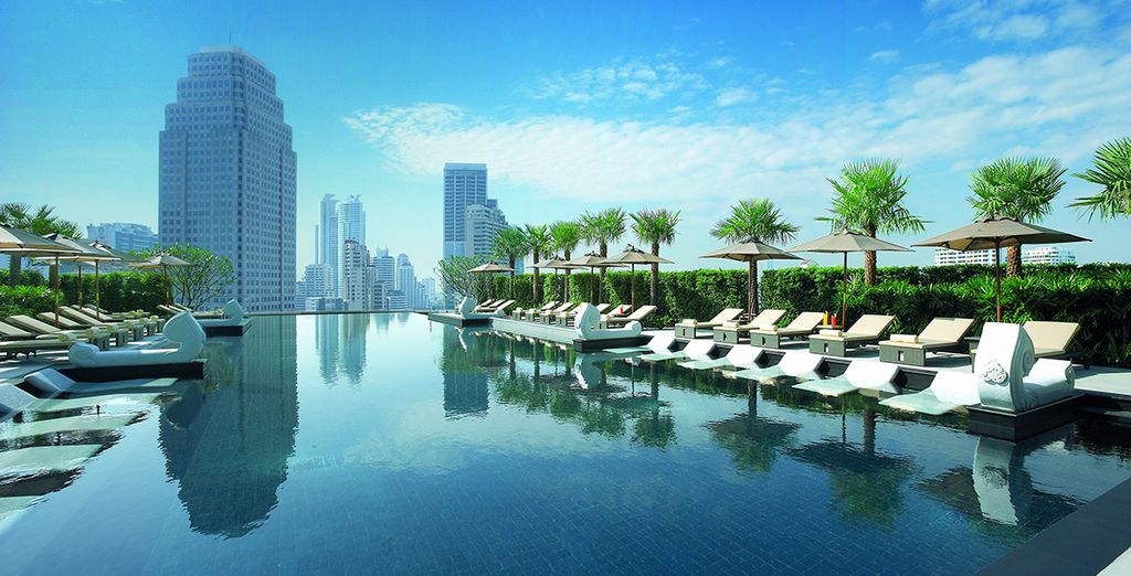 Hôtel de luxe avec piscine extérieure et espace détente offrant une vue panoramique sur la ville de Bangkok