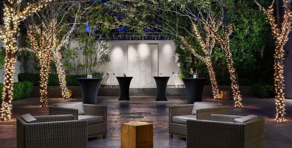 Terrasse du Luxe Sunset Boulevard Hotel 4 étoiles à Los Angeles, ses palmiers illuminés à la tombée du jour